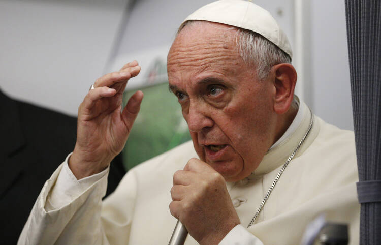 Pope Francis answers questions from journalists aboard his flight from Asuncion to Rome July 12. (CNS photo/Paul Haring) 