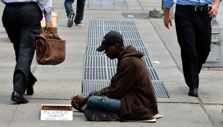 In this June 16, 2014, file photo, a homeless man sits on a sidewalk in New York City. (CNS photo/Justin Lane, EPA)