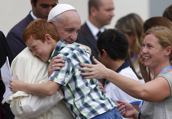 Pope Francis embraces Simone Zanini, 8, while greeting the disabled during his general audience in St. Peter's Square at the Vatican Sept. 2. (CNS photo/Paul Haring)