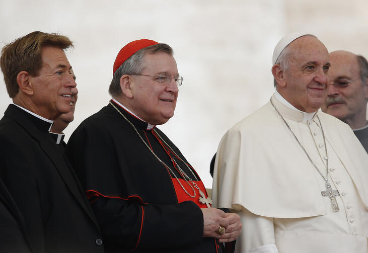 U.S. Cardinal Raymond L. Burke, patron of the Knights and Dames of Malta, center left, and a group of priests pose with Pope Francis during his general audience in St. Peter's Square at the Vatican Sept. 2. (CNS photo/Paul Haring)