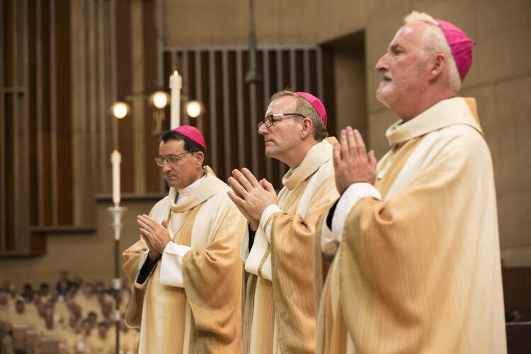 Auxiliary Bishops Joseph V. Brennan, Robert E. Barron and David G. O'Connell, pray during their Sept. 8 episcopal ordination at the Cathedral of Our Lady of the Angels in Los Angeles. (CNS photo/John Rueda, The Tidings) 