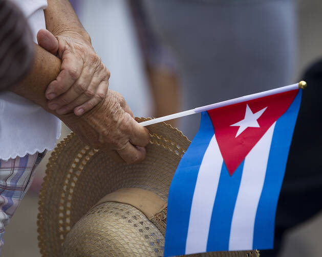 Woman holds Cuban flag near Havana's apostolic nunciature Sept. 19. (CNS photo/Tyler Orsburn)