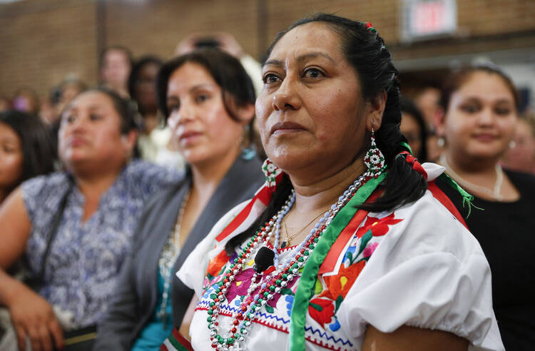 Women listen as Pope Francis talks with immigrant families at Our Lady Queen of Angels School in the East Harlem area of New York Sept. 25. (CNS photo/Paul Haring)