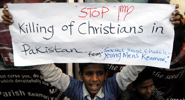 A Pakistani Christian boy holds a banner during a late March protest in Karachi after attacks on churches in Lahore last year.