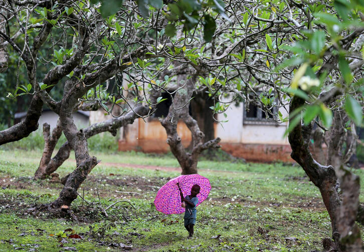 A boy walks with an umbrella during a shower in Bambari, Central African Republic, Oct. 17. Faith leaders there hope Pope Francis' November visit will help with the peace process. (CNS photo/Goran Tomasevic, Reuters)