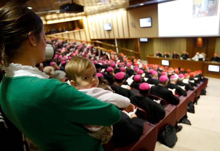 A mother holds her child at the Synod on the family on Oct. 24. (CNS photo/Paul Haring)