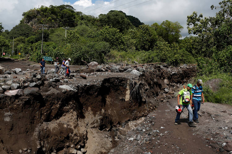 Residents walk near a damaged bridge in Comala, Mexico, Oct. 24. (CNS photo/Tomas Bravo, Reuters)