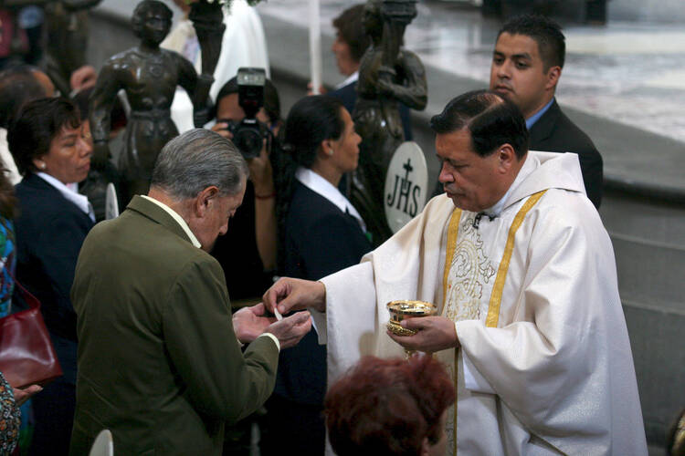 Cardinal Norberto Rivera Carrera of Mexico City distributes Communion during Mass in early May at Mexico City's Metropolitan Cathedral. (CNS photo/Ricardo Castelan, EPA)