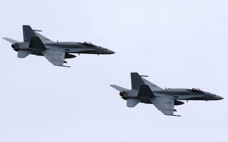 In this May 31, 2014, file photo, two Royal Canadian Air Force F-18 Hornet jets fly over Romania. Canada's new government has decided to stop airstrikes against Islamic State in the Middle East. (CNS photo/Mircea Rosca, EPA)