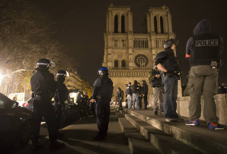 Armed police officers go on foot patrol around Notre Dame Cathedral in Paris Nov. 14. Dozens of people were killed in a series of attacks in Paris Nov. 13. (CNS photo/Ian Langsdon, EPA) 