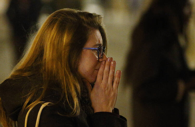 A woman mourns in Republique square in Paris Nov. 14 as people gather in memory of victims of terrorist attacks. Coordinated attacks the previous evening claimed the lives of 129 people. The Islamic State claimed responsibility. (CNS photo/Paul Haring) 
