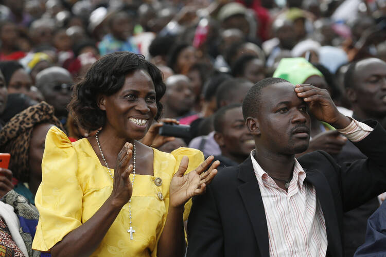 People wait for Pope Francis' arrival to celebrate Mass for the martyrs of Uganda near the Catholic shrine at Namugongo in Kampala, Uganda Nov. 28. (CNS photo/Paul Haring)