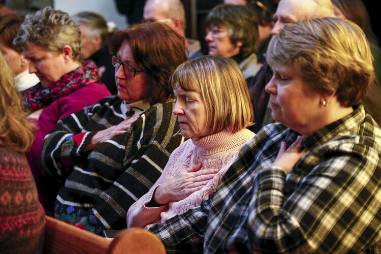 People pray during a vigil at All Souls Unitarian Universalist Church Nov. 28, the day after a gunman opened fire on a Planned Parenthood clinic in Colorado Springs, Colo. (CNS photo/Isaiah J. Downing, Reuters)