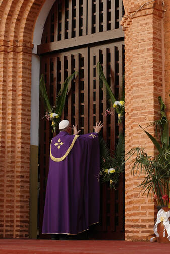 Pope Francis opens the Holy Door as he begins the Holy Year of Mercy at the start of a Mass with priests, religious, catechists and youths at the cathedral in Bangui, Central African Republic, Nov. 29. (CNS photo/Paul Haring) 