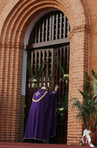 Pope Francis opens the Holy Door as he begins the Holy Year of Mercy at the start of a Mass with priests, religious, catechists and youths at the cathedral in Bangui, Central African Republic, Nov. 29. (CNS photo/Paul Haring)