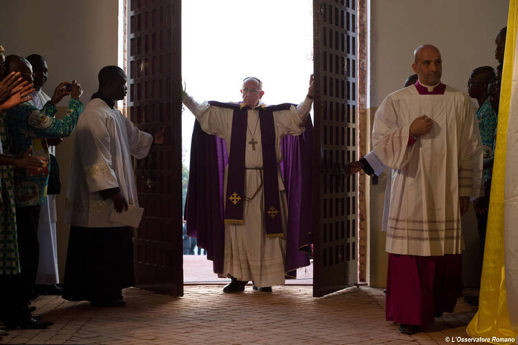 Pope Francis walks through the Holy Door after opening it to begin the Holy Year of Mercy at the start of a Mass with priests, religious, catechists and youths at the cathedral in Bangui, Central African Republic, Nov. 29. (CNS photo/L'Osservatore Romano)