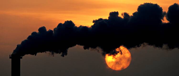 Smoke billows from a plant in late October at sunset in Wismar, Germany. (CNS photo/Daniel Reinhardt, EPA)