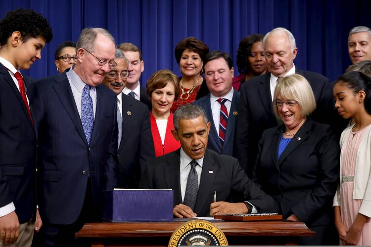 U.S. President Barack Obama signs the signs the Every Student Succeeds Act into law in the Eisenhower Executive Office Building at the White House in Washington Dec. 10. (CNS photo/Jonathan Ernst, Reuters)