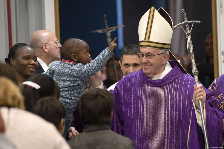  Pope Francis greets a boy during a visit to a Caritas center for the homeless near the Termini rail station in Rome Dec. 18. The pope opened a Door of Mercy at the center. (CNS photo/L'Osservatore Romano, handout)