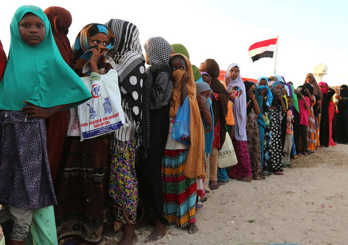 Yemeni refugees wait in line for food rations in December 2015 at a makeshift camp in Somalia's capital, Mogadishu. (CNS photo/Feisal Omar, Reuters)