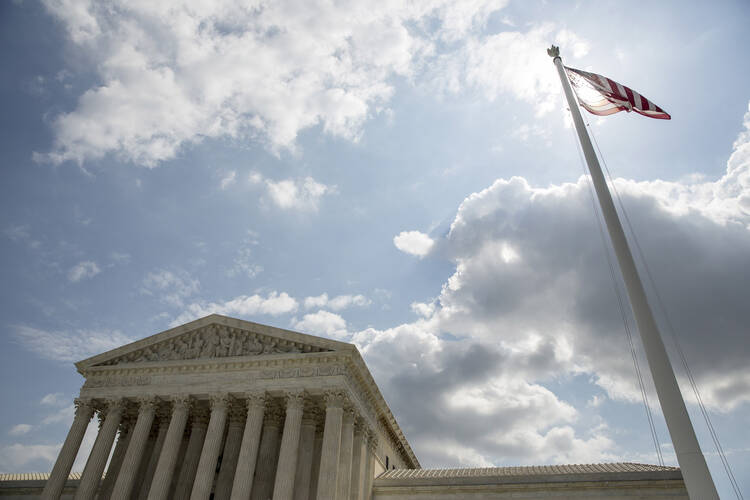 The U.S. flag flies in front of the Supreme Court in Washington in this file photo from May 18, 2015. (CNS photo/Joshua Roberts, Reuters)