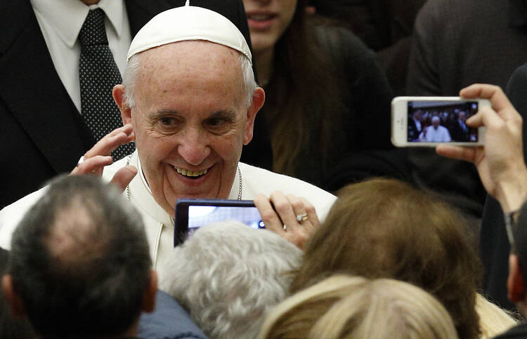 Pope Francis greets people during an audience for pilgrimage workers in Paul VI hall at the Vatican Jan. 21. (CNS photo/Paul Haring)