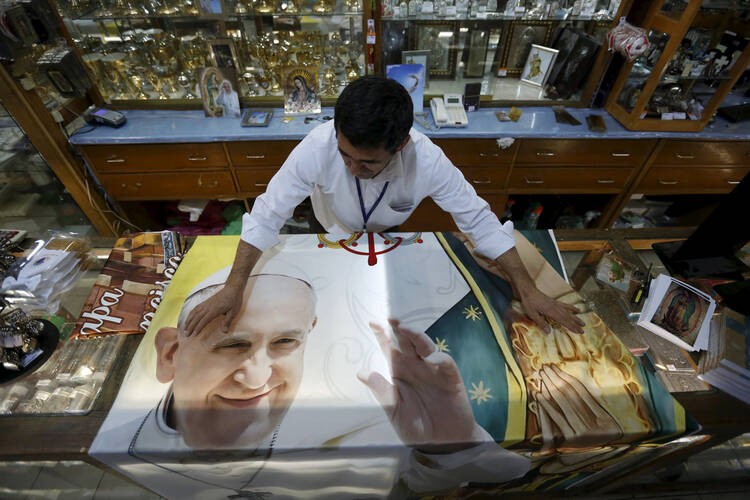 A vendor displays a blanket with an image of Pope Francis Jan. 27, to be sold inside a store of religious items in Mexico City. (CNS photo/Edgard Garrido, Reuters)