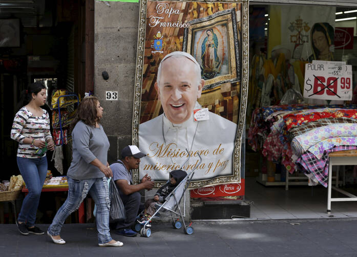 People walks past a Pope Francis banner outside a store in Mexico City Feb. 7. (CNS photo/Henry Romero, Reuters) 