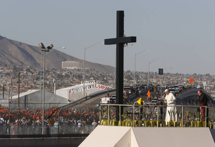 Pope Francis prays at a cross on the border with El Paso, Texas, before celebrating Mass at the fairgrounds in Ciudad Juarez, Mexico, Feb. 17. (CNS photo/Paul Haring) 