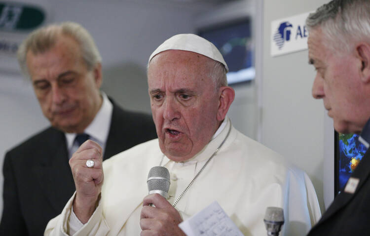 Pope Francis answers questions from journalists aboard his flight from Ciudad Juarez, Mexico, to Rome Feb. 17. 