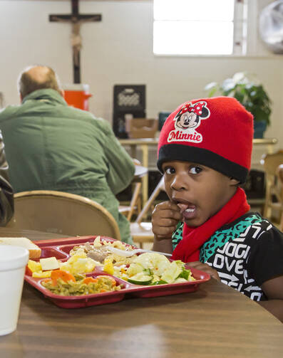 A young girl eats supper at the North End Soup Kitchen in Flint, Mich., Feb. 18. The soup kitchen is operated by Catholic Charities. (CNS photo/Jim West) 