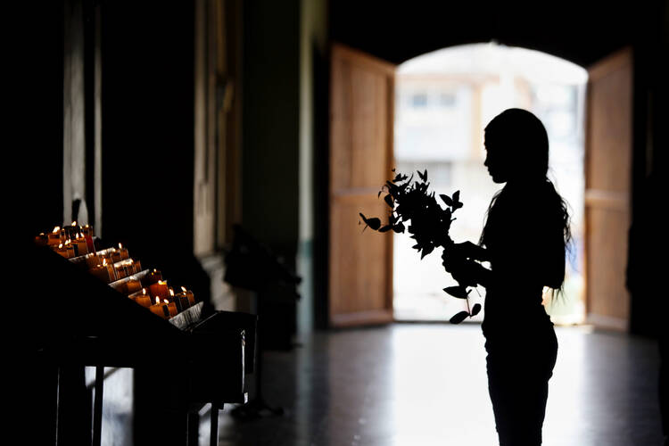 A woman prays in Cali, Colombia, in this April 13, 2014, file photo. (CNS photo/Christian Escobar Mora, EPA)