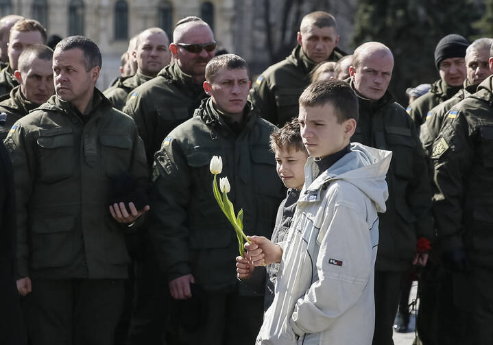 Ukrainian boys in Kiev hold flowers March 16 during a ceremony marking the second anniversary of people killed in the pro-Russian separatist conflict. (CNS photo/Gleb Garanich, Reuters)