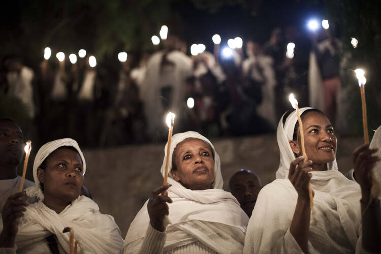 Ethiopian Orthodox Christians light candles and pray during the Holy Fire ceremony in Jerusalem's Church of the Holy Sepulcher in this April 19, 2014, file photo. (CNS photo/Abir Sultan, EPA)