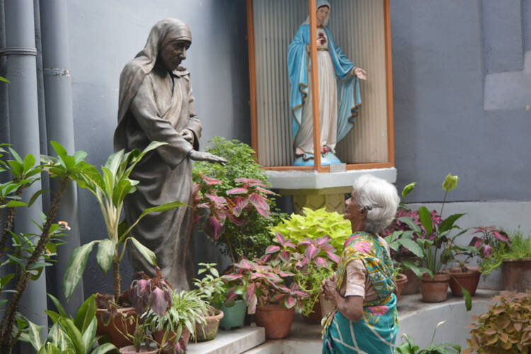 Margaret Rose of Kolkata, India, prays before a statue of Blessed Teresa at the headquarters of the Missionaries of Charity March 18. (CNS photo/Saadia Azim)