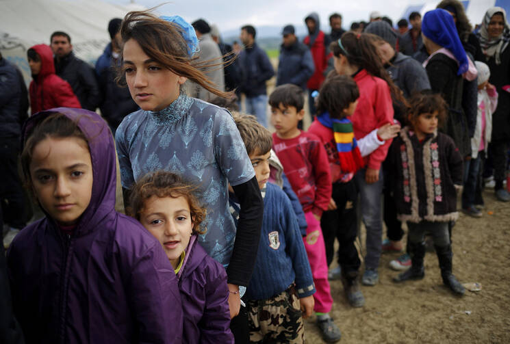 Young refugees wait in line for tea at a makeshift camp April 11 at the Greek-Macedonian border near the village of Idomeni, Greece. Pope Francis will travel to Lesbos, Greece, April 16. (CNS photo/Stoyan Nenov, Reuters) 