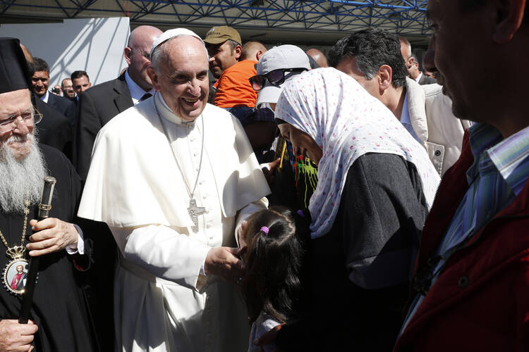 Pope Francis greets refugees who are traveling to Rome with him at the international airport in Mytilene on the island of Lesbos, Greece, April 16, 2016. The pope brought 12 refugees to Italy on his plane. (CNS photo/Paul Haring)