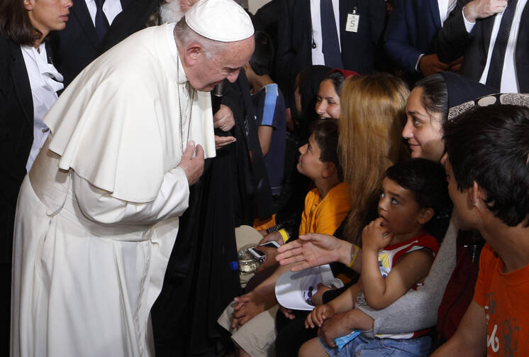 Pope Francis greets a Muslim woman as he meets refugees at the Moria refugee camp on the island of Lesbos, Greece, April 16, 2016. The pope put his hand over his heart and bowed when meeting Muslim women. (CNS photo/Paul Haring) 