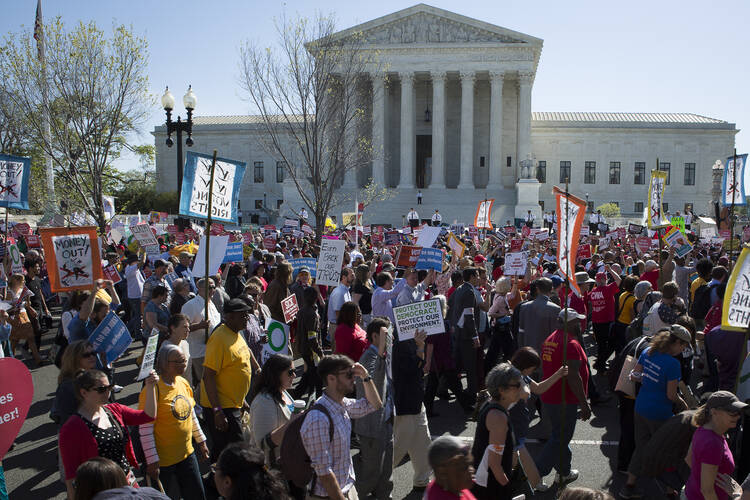 Demonstrators gather outside the U.S. Supreme Court in Washington April 18 as the justices hear oral arguments in a challenge by several states to President Barack Obama's deferred deportation programs. (CNS photo/Tyler Orsburn)