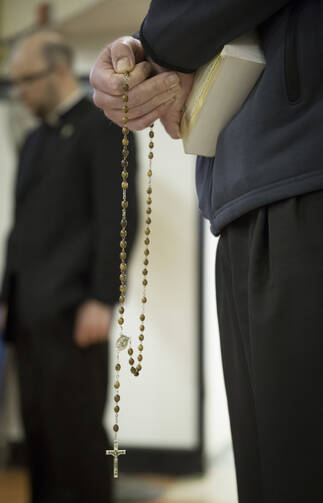 A seminarian from St. John's Seminary in Brighton, Mass., holds a rosary as he prepares to participate in a "Grill the Seminarians" discussion April 3 with members of a youth group from St. Patrick Church in Providence, R.I. (CNS photo/Chaz Muth)