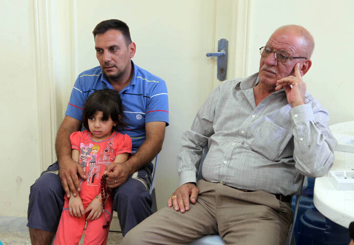 A Christian family who fled from violence in Mosul, Iraq, sit in the room of a church in 2014 in Amman, Jordan. (CNS photo/Jamal Nasrallah, EPA)