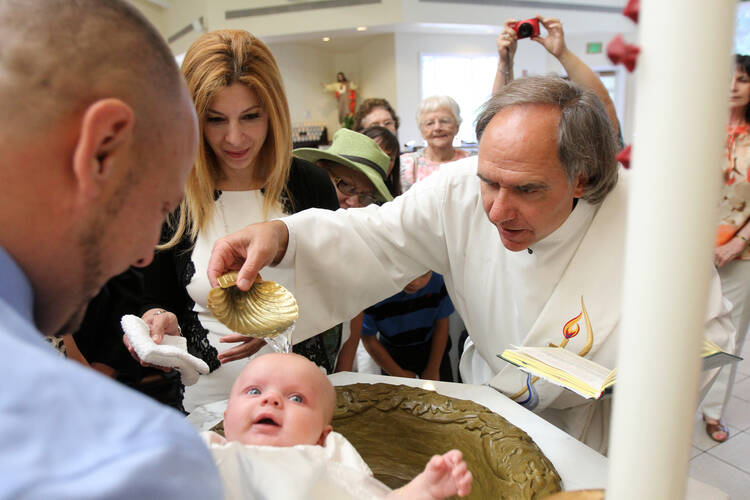 Deacon Mark Herrmann baptizes 4-month-old Victoria Marie Domke at St. Jude Church in Mastic Beach, N.Y., in 2013. (CNS photo/Gregory A. Shemitz)