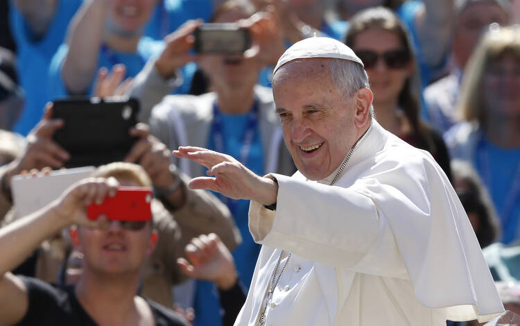 Pope Francis greets the crowd during his general audience in St. Peter's Square at the Vatican May 18. (CNS photo/Paul Haring) 