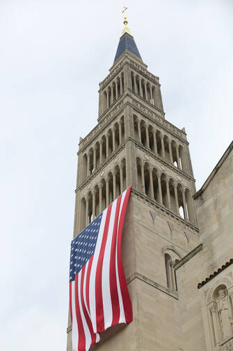 A large American flag is seen hanging from the bell tower of the Basilica of the National Shrine of the Immaculate Conception in Washington July 4, 2015. The U.S. bishops' fifth annual Fortnight for Freedom opens June 21. (CNS photo/Bob Roller)