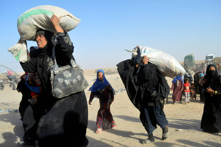 Women displaced by Islamic State militant violence arrive at a military base in Ramadi, Iraq, in late June. (CNS photo, Osamah Waheeb, Reuters)