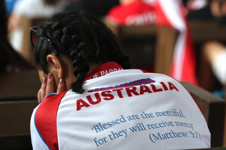 An Australian pilgrim prays while waiting for Philippine Cardinal Luis Tagle of Manila to arrive for a talk on July 27, 2016 at St. Joseph Church in Krakow, Poland. (CNS photo/Bob Roller) 