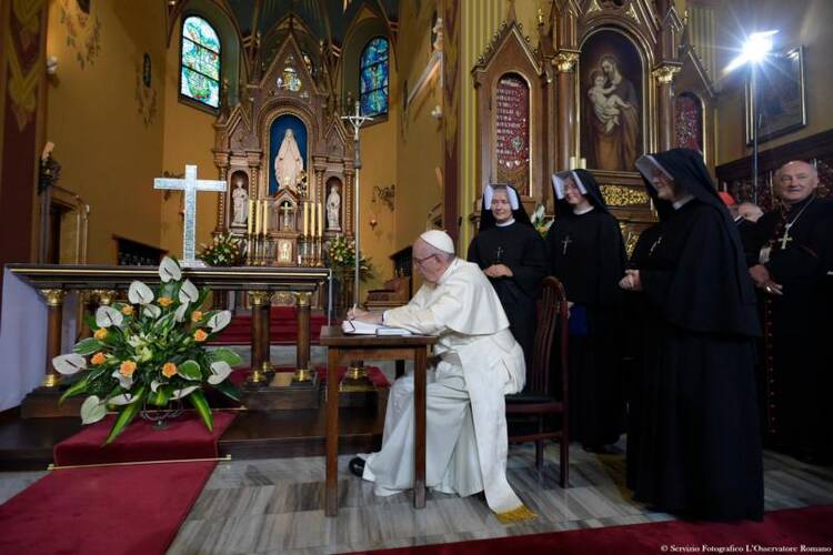 Pope Francis signs a guest book after praying at the Shrine of Divine Mercy in Lagiewniki, a suburb of Krakow, Poland, on July 30. (CNS photo/L'Osservatore Romano) 