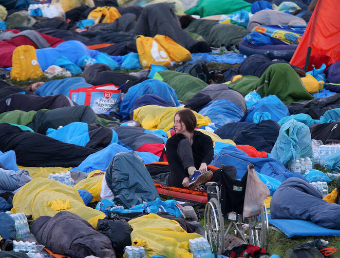 A pilgrim puts on her shoe at sunrise July 31, hours before Pope Francis celebrates the World Youth Day closing Mass at the Field of Mercy in Krakow, Poland. (CNS photo/Bob Roller) 