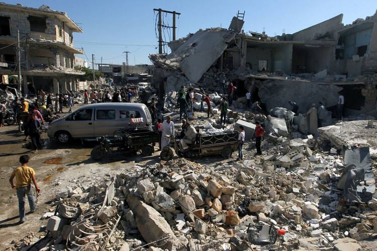 People gather July 25 at a site hit by airstrikes in a rebel-held neighborhood in Aleppo, Syria. (CNS photo/Ammar Abdullah, Reuters)