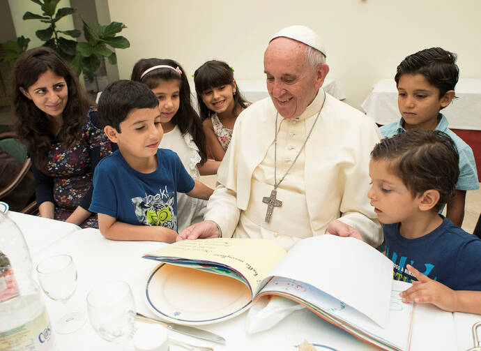 Pope Francis sits with refugee children from Syria at the Vatican Aug. 11. (CNS photo/L'Osservatore Romano via Reuters)